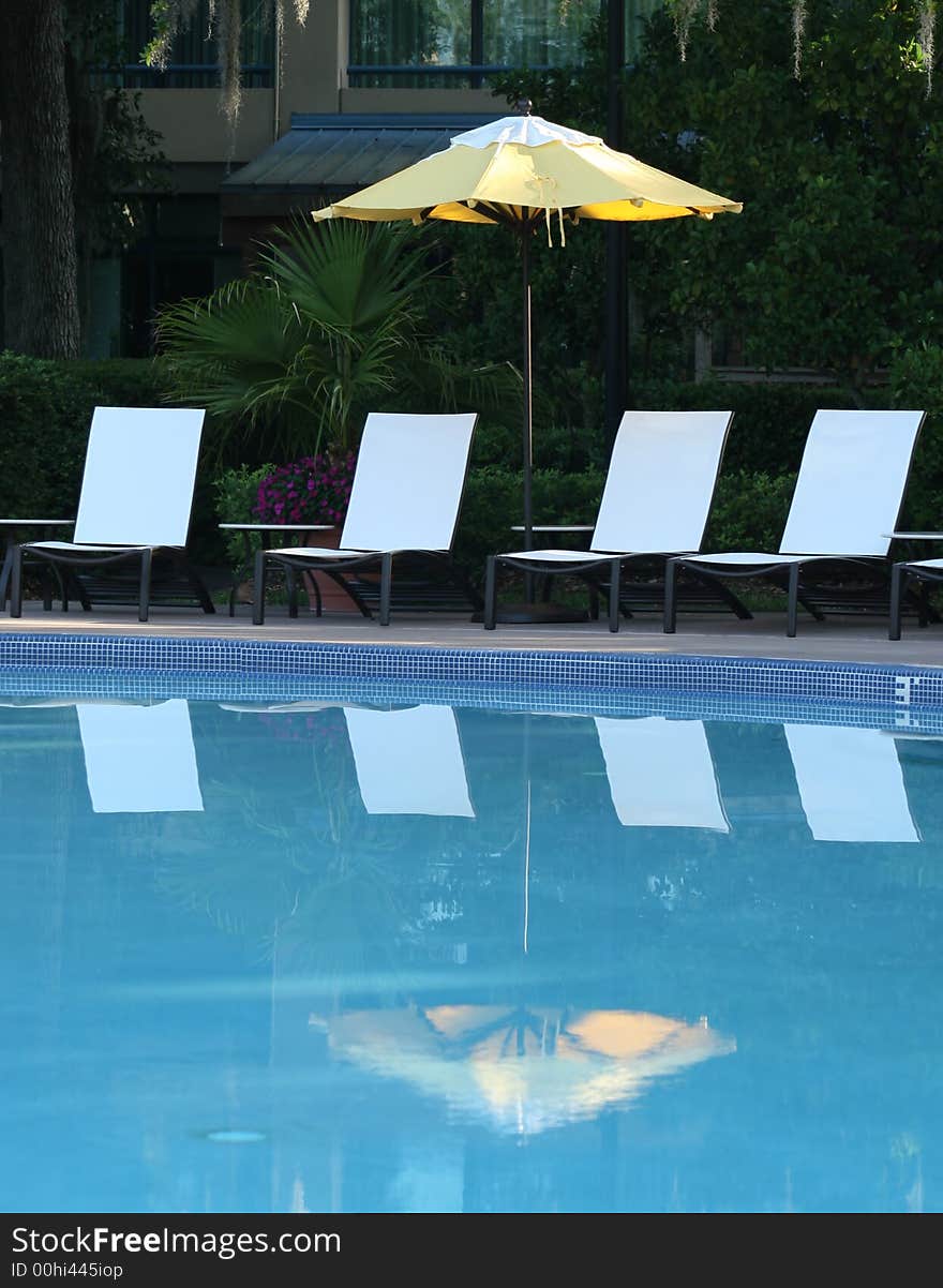 Umbrella and Chairs Reflected in Pool. Umbrella and Chairs Reflected in Pool