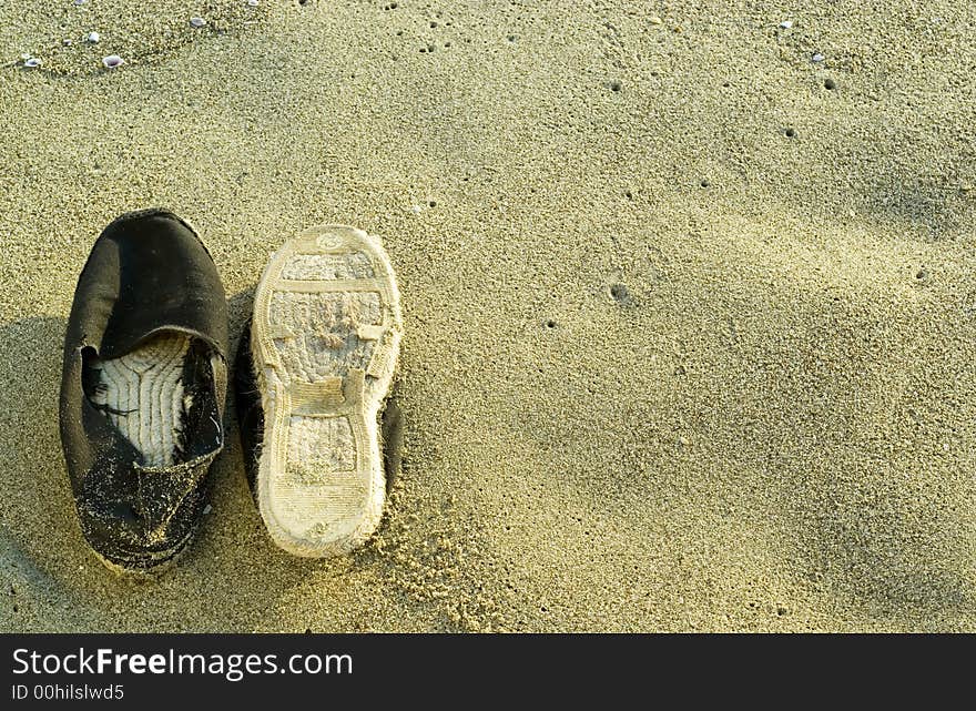 Stylish beach shoes photographed on the sand at sunset. Composition leaves a lot of space for typing. Stylish beach shoes photographed on the sand at sunset. Composition leaves a lot of space for typing