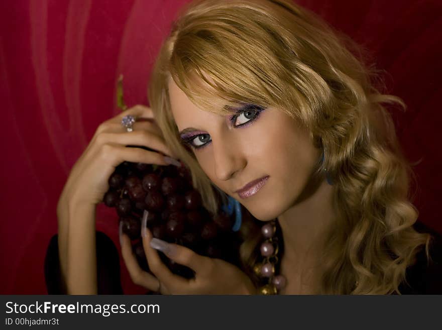 Young beautiful  blond girl with grapes