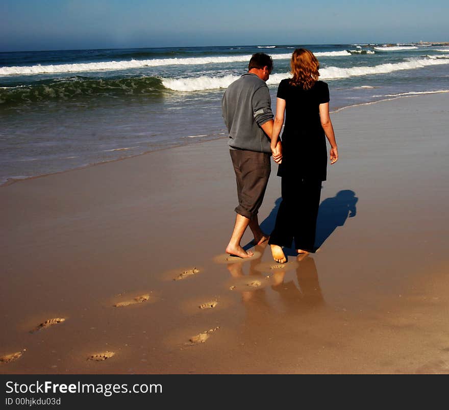 Couple walking on the beach holding hands