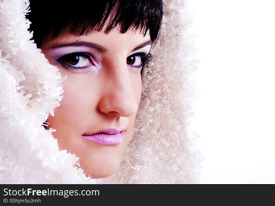 Portrait of a woman with white fur draped over her black hair looking at the camera