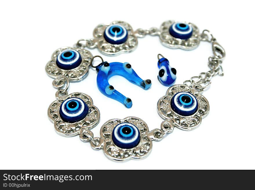 Metallic bracelet talisman and horse-shoe and drop talisman with blue eyes. Metallic bracelet talisman and horse-shoe and drop talisman with blue eyes.