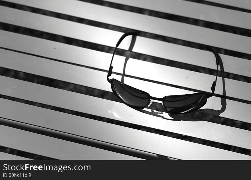 Sun glasses on beach chair concept in black and white