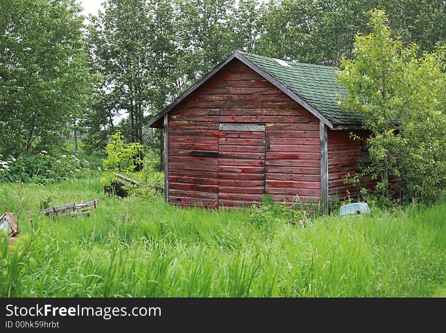 An old abandoned red granary on abandoned farm site. An old abandoned red granary on abandoned farm site.