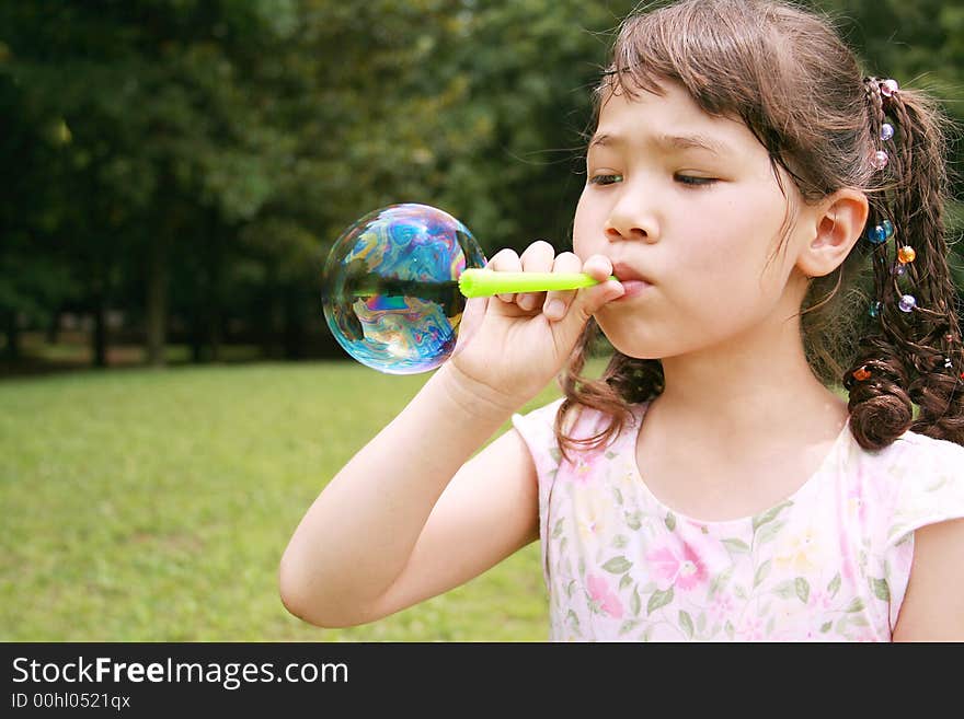 Girl blowing bubble in the park