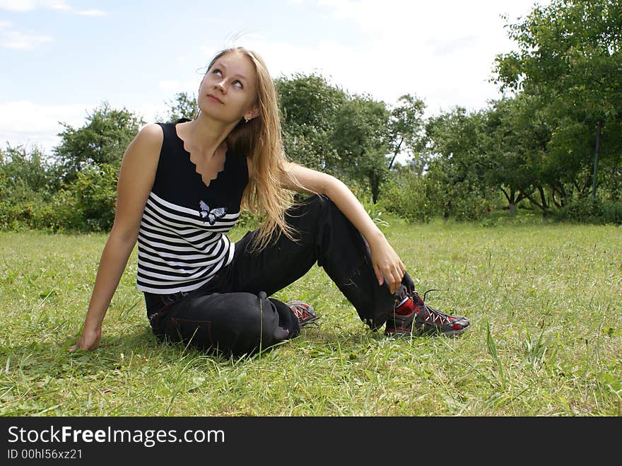 The girl sits on a grass. The girl sits on a grass