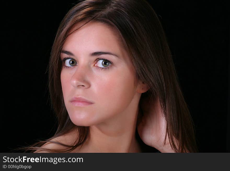 Portrait of young woman against black background