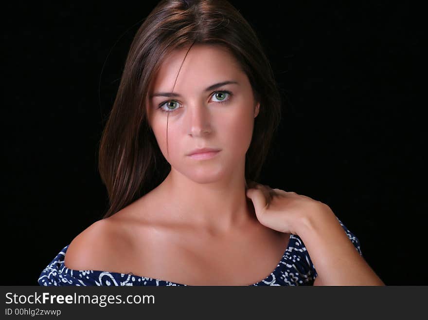 Portrait of young woman against black background