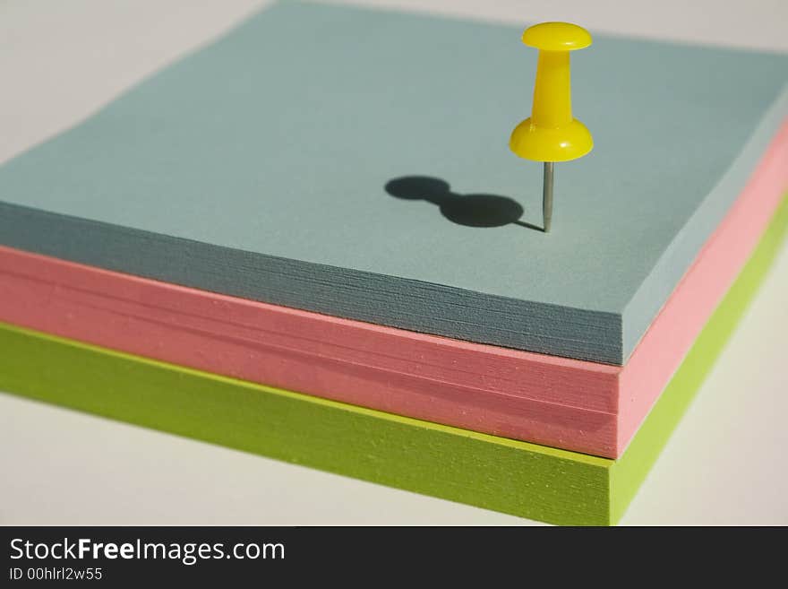 Pad of sticky notes with a yellow pin