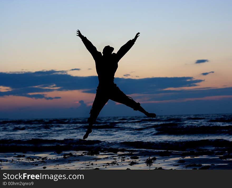 Man jumping near sea at sunset. Man jumping near sea at sunset.