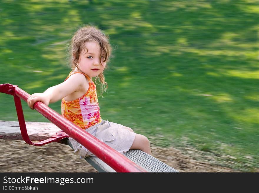 A little girl spinning on a merry-go-round. A little girl spinning on a merry-go-round