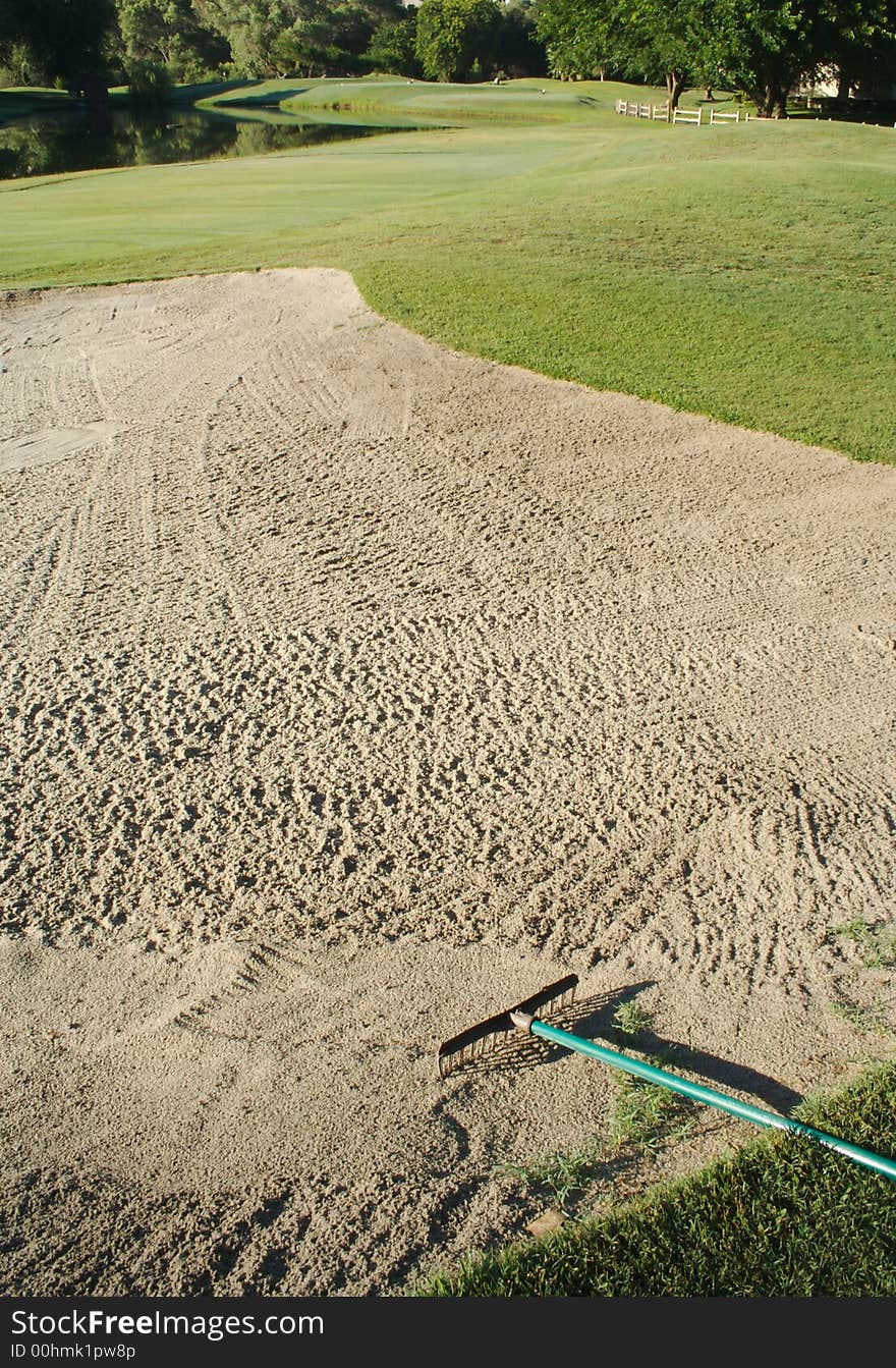 Golf fairway, lake, sand trap and rake. Golf fairway, lake, sand trap and rake.