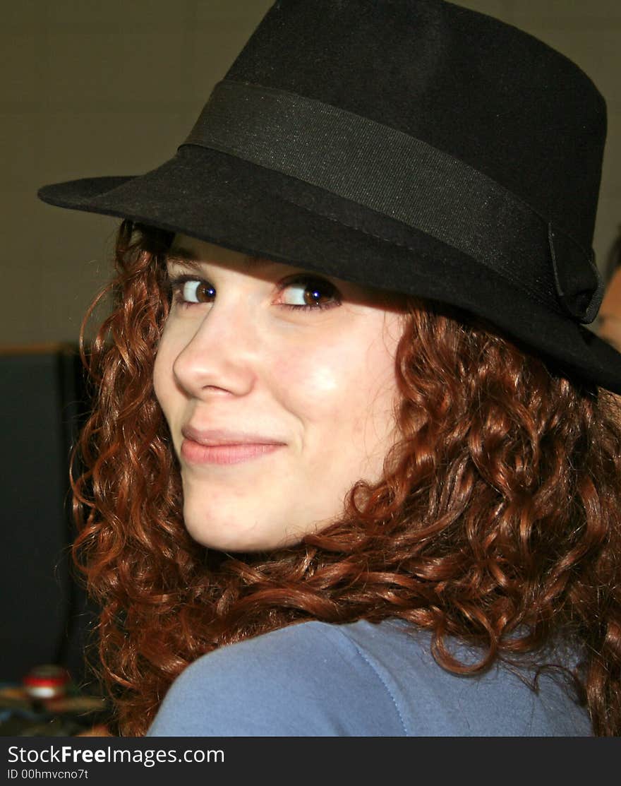 Cute teenage with black hat on and looking over her shoulder. Cute teenage with black hat on and looking over her shoulder