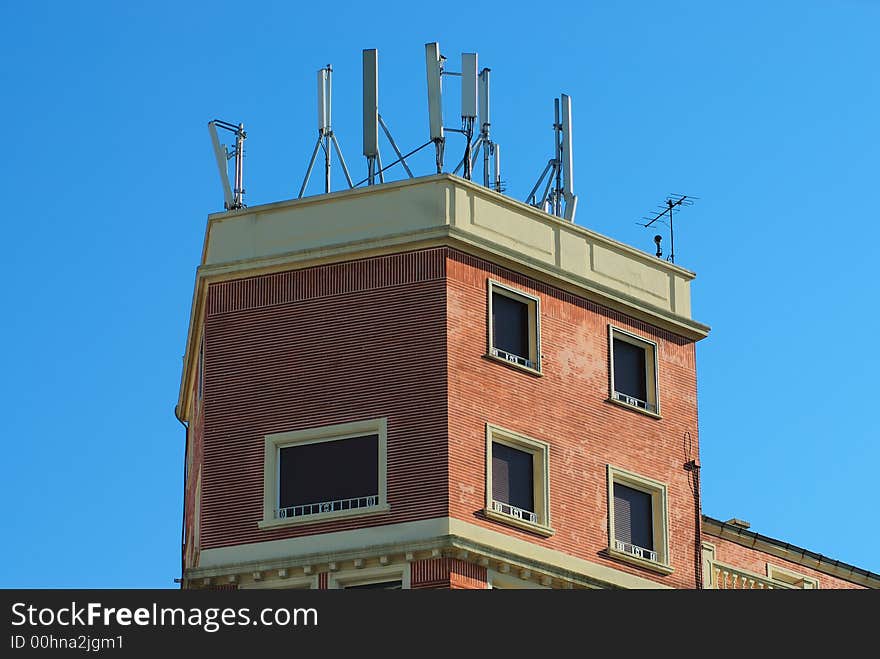 A cell phones aerial on a building roof. A cell phones aerial on a building roof