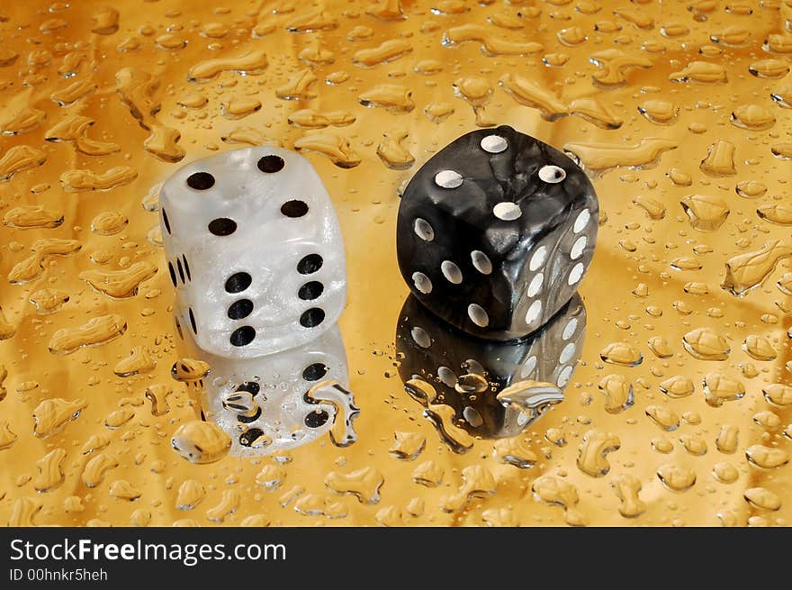 Dice on golden background with droplets showing a hard eight. Dice on golden background with droplets showing a hard eight