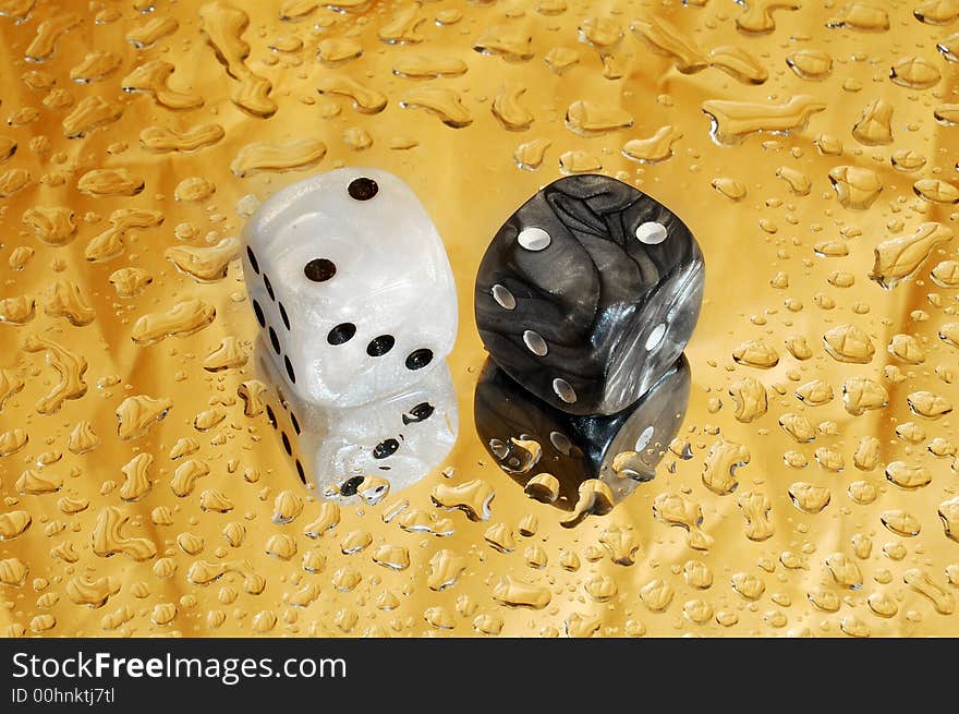 Dice on golden background with droplets showing a hard four. Dice on golden background with droplets showing a hard four