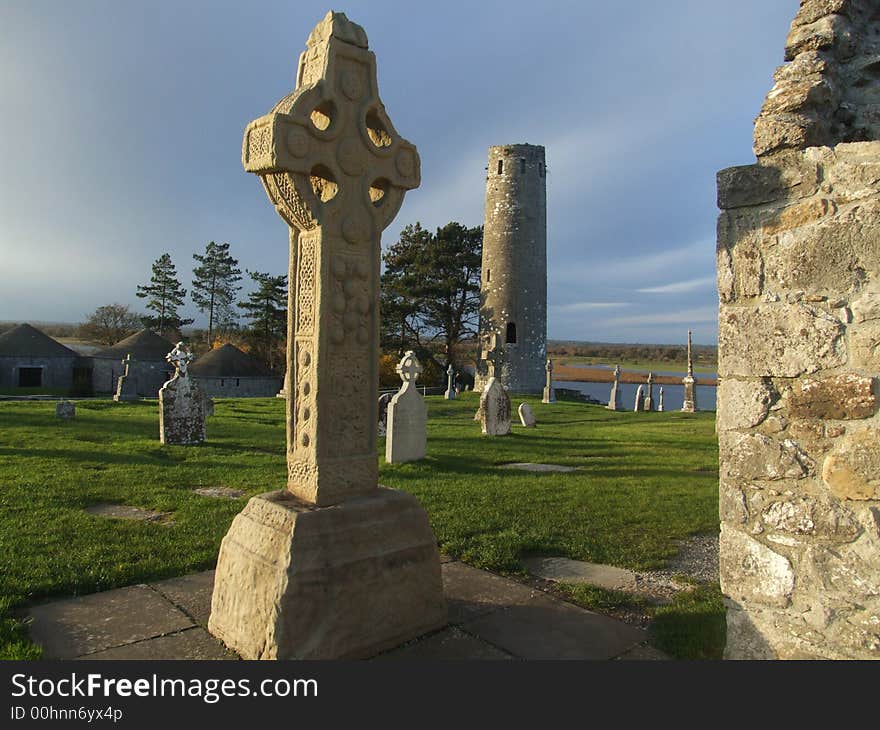 View of Celtic cross and old cemetry and round tower ruins dating to 10th century Ireland