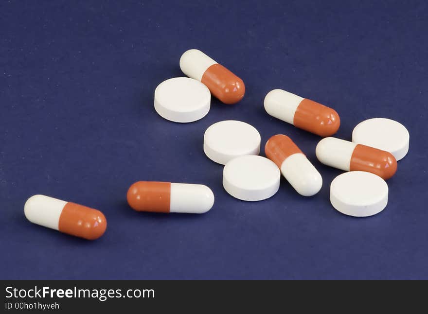 Mixed medical tablets on a blue background. Mixed medical tablets on a blue background