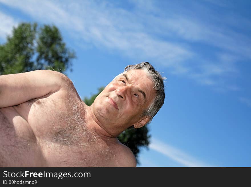 Grey man meditates outdoor in the summer