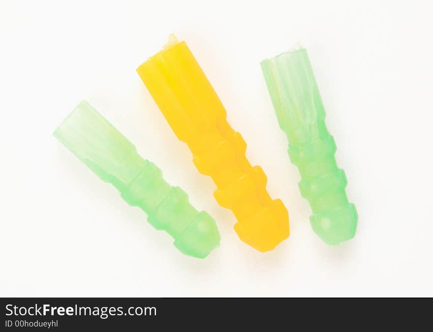 Three dowels in green and yellow on a white surface. Three dowels in green and yellow on a white surface