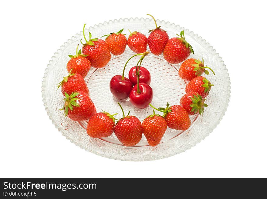 Strawberries and three cherries on a glass dish, isolated on white background. Strawberries and three cherries on a glass dish, isolated on white background