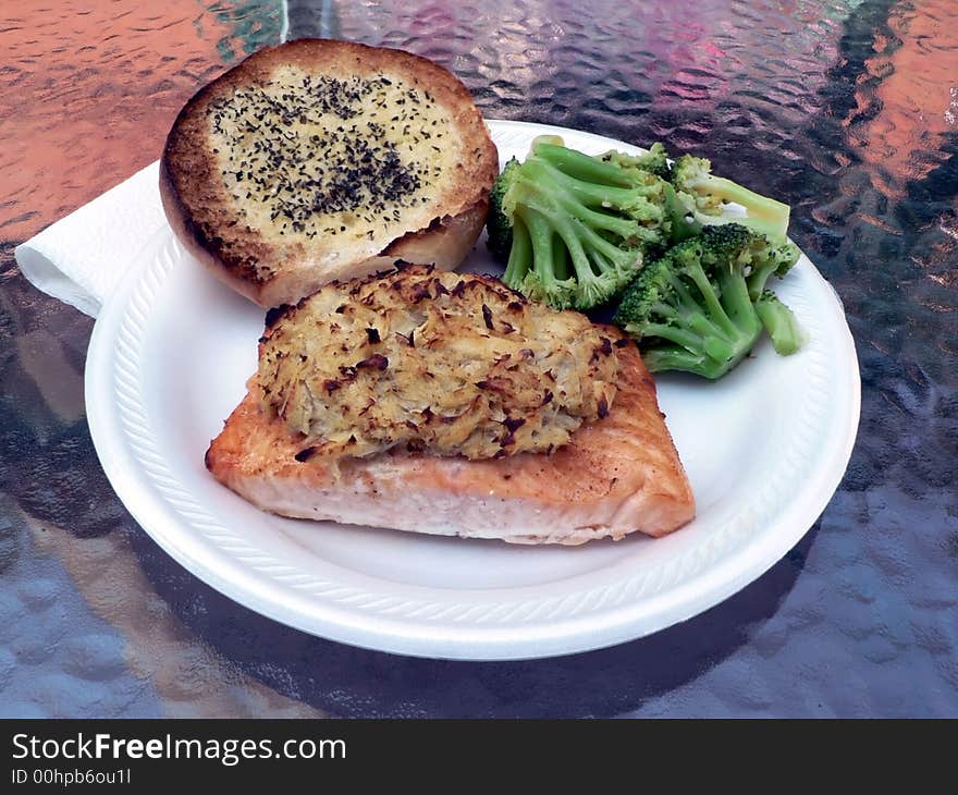 Dinner of salmon stuffed with crabmeat with brocolli and garlic bread on the side. Dinner of salmon stuffed with crabmeat with brocolli and garlic bread on the side