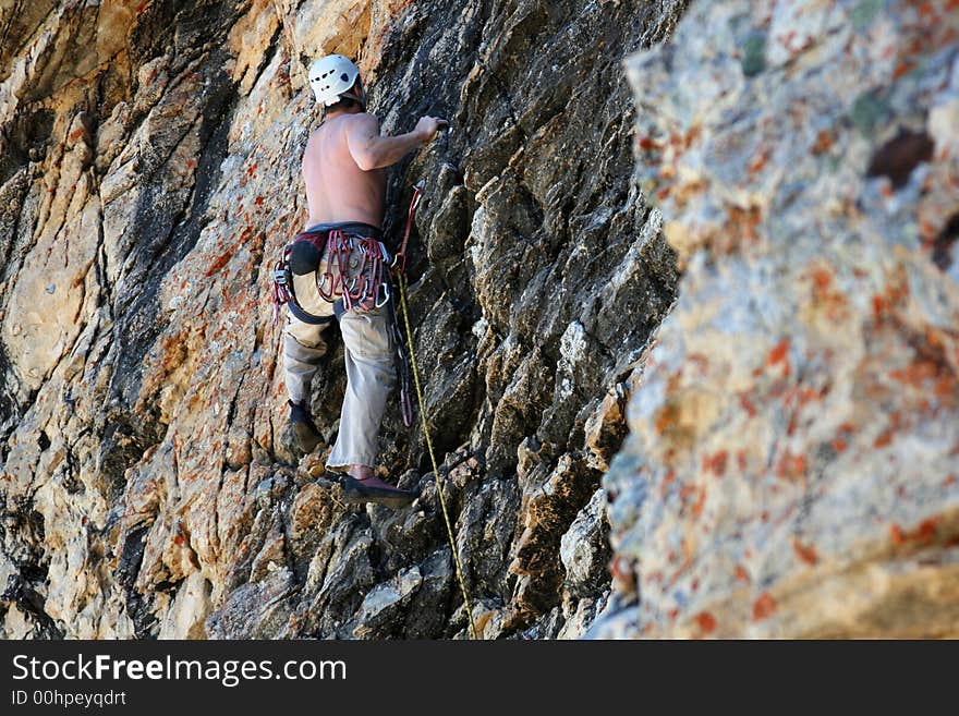 A man on a rock climb with textured rock. A man on a rock climb with textured rock