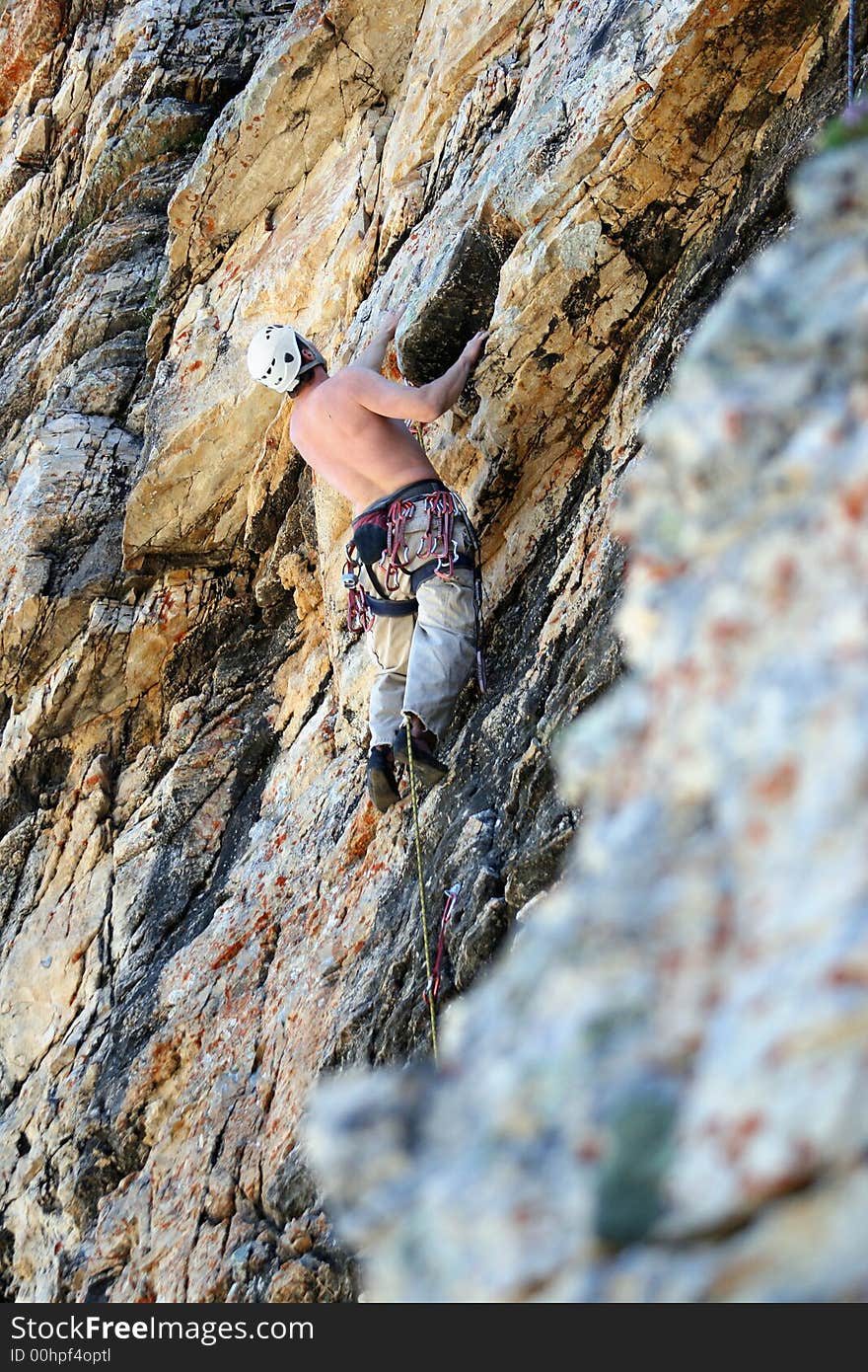 A man on a rock climb with textured rock. A man on a rock climb with textured rock