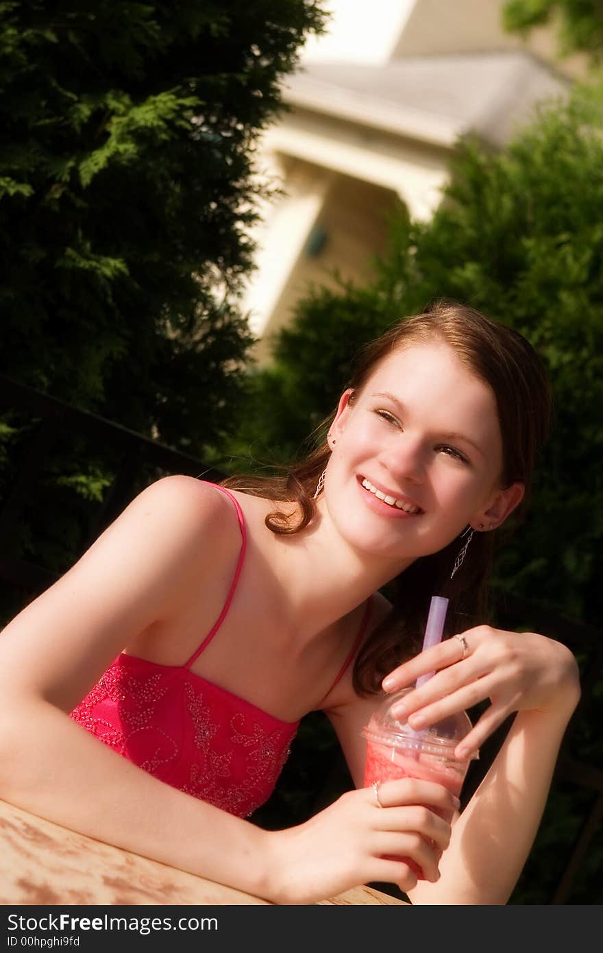 Beautiful, happy teen in formal wear outside with a fruity drink. Beautiful, happy teen in formal wear outside with a fruity drink