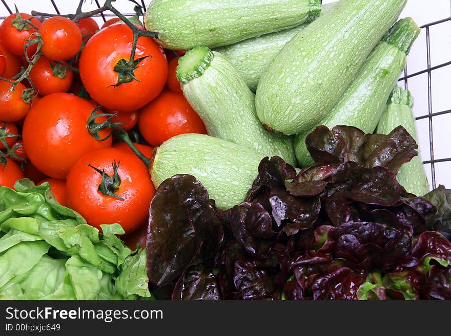 Diferents fresh vegetables on iron basket with drops