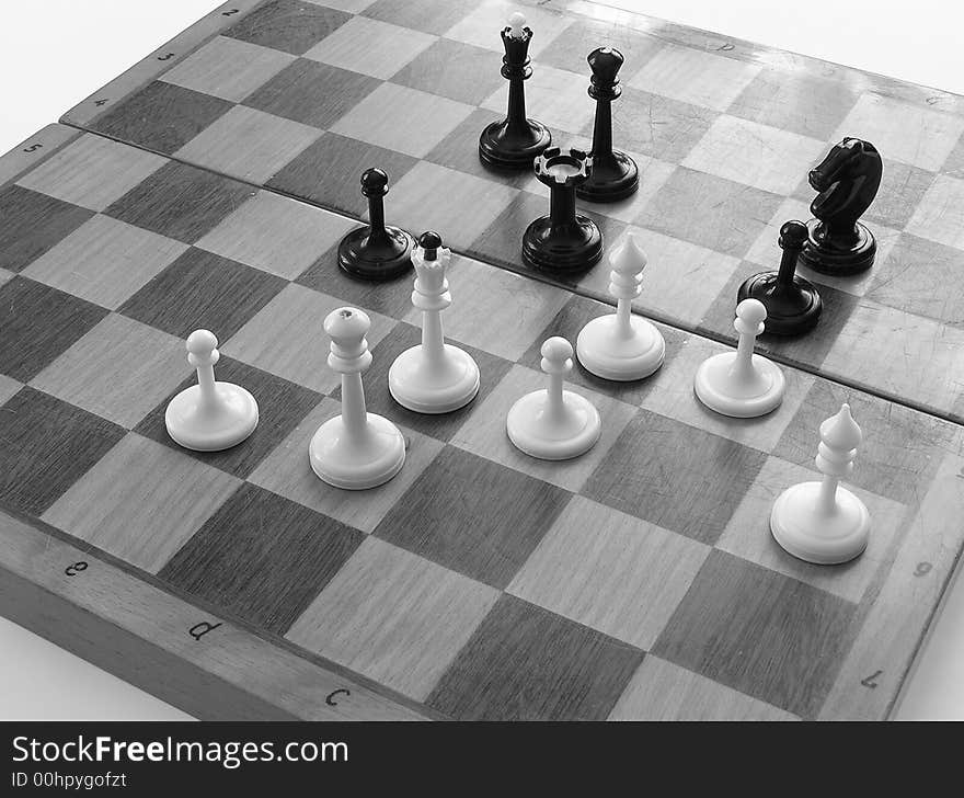 On it is black a white photo a board for a chess and a chess on it.