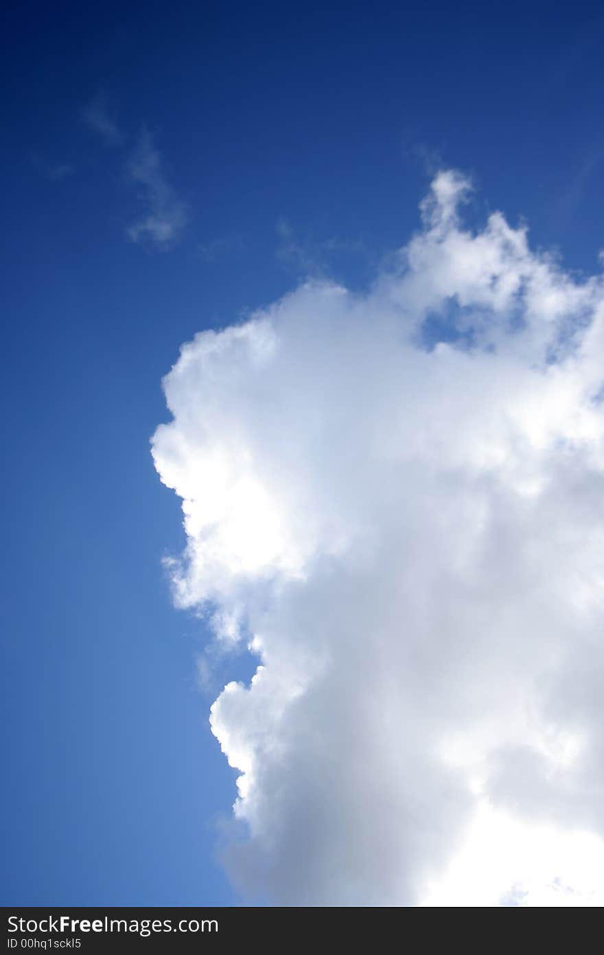 Deep blue sky with white fluffy cloud