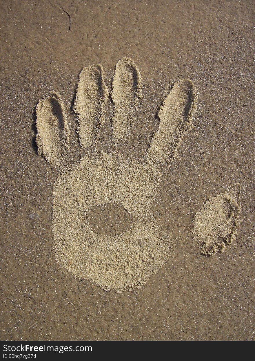 Photo of a hand print on a sandy beach. Photo of a hand print on a sandy beach