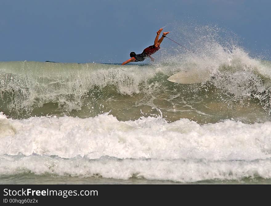 Surfer takes off on a wave in Thailand. Surfer takes off on a wave in Thailand