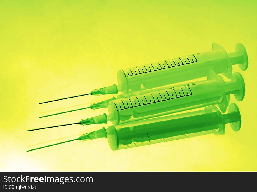 Two disposable syringes on green background. Two disposable syringes on green background