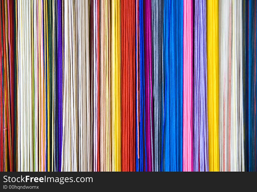 Colourful threads that form a diverse coloured background.