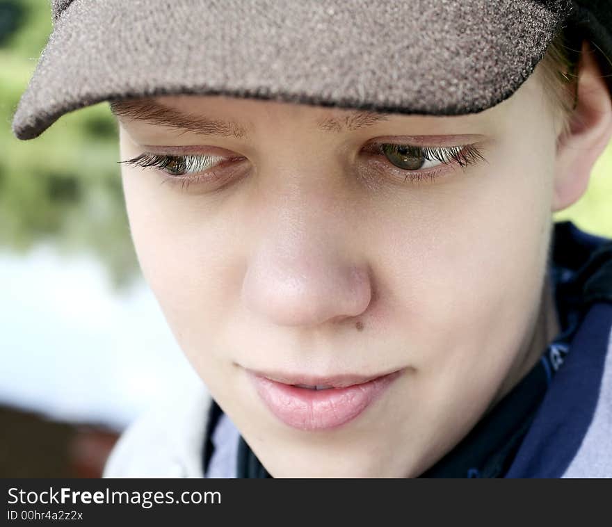 Young woman with cap looking down. Young woman with cap looking down