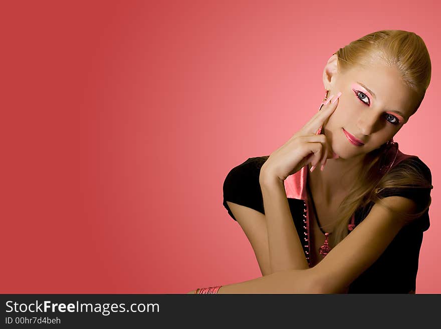 Young beautiful blond girl on pink background with space