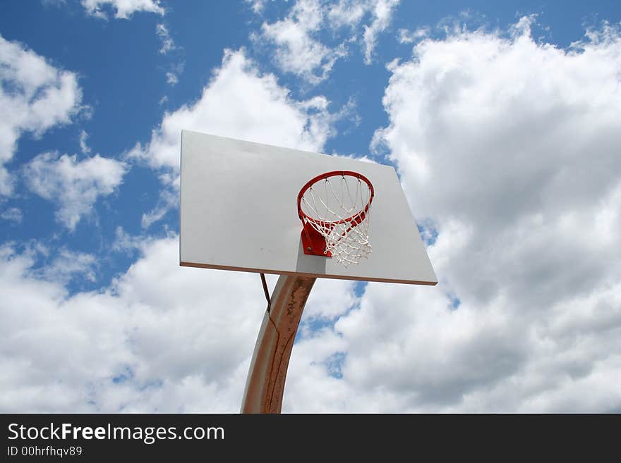 An image of a Basketball hoop against a cloudy sky. An image of a Basketball hoop against a cloudy sky