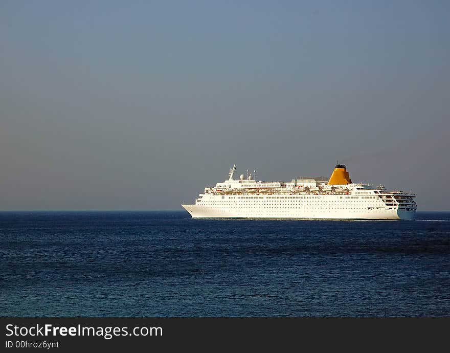 Big Cruise-ship in deep blue water, sunset warm light. Big Cruise-ship in deep blue water, sunset warm light