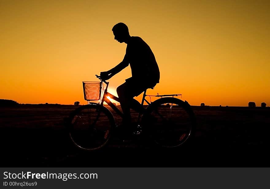 Man and  bike  silhouette in orange sunrise. Man and  bike  silhouette in orange sunrise