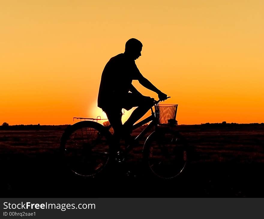 Man and  bike  silhouette in orange sunrise. Man and  bike  silhouette in orange sunrise