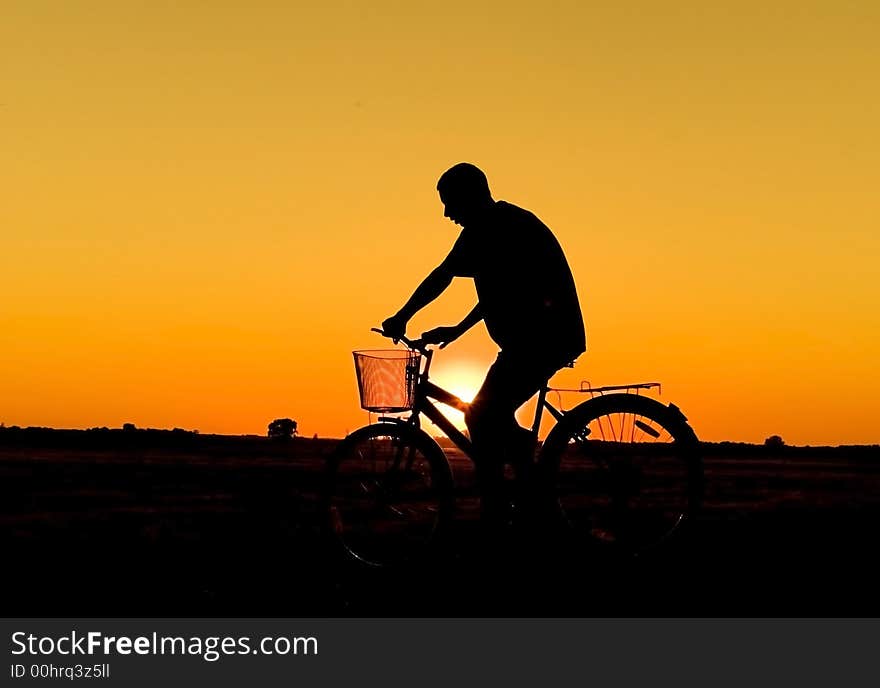 Man and  bike  silhouette in orange sunrise. Man and  bike  silhouette in orange sunrise