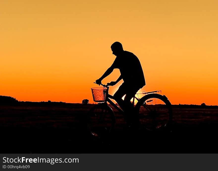 Man and bike silhouette in orange sunrise. Man and bike silhouette in orange sunrise