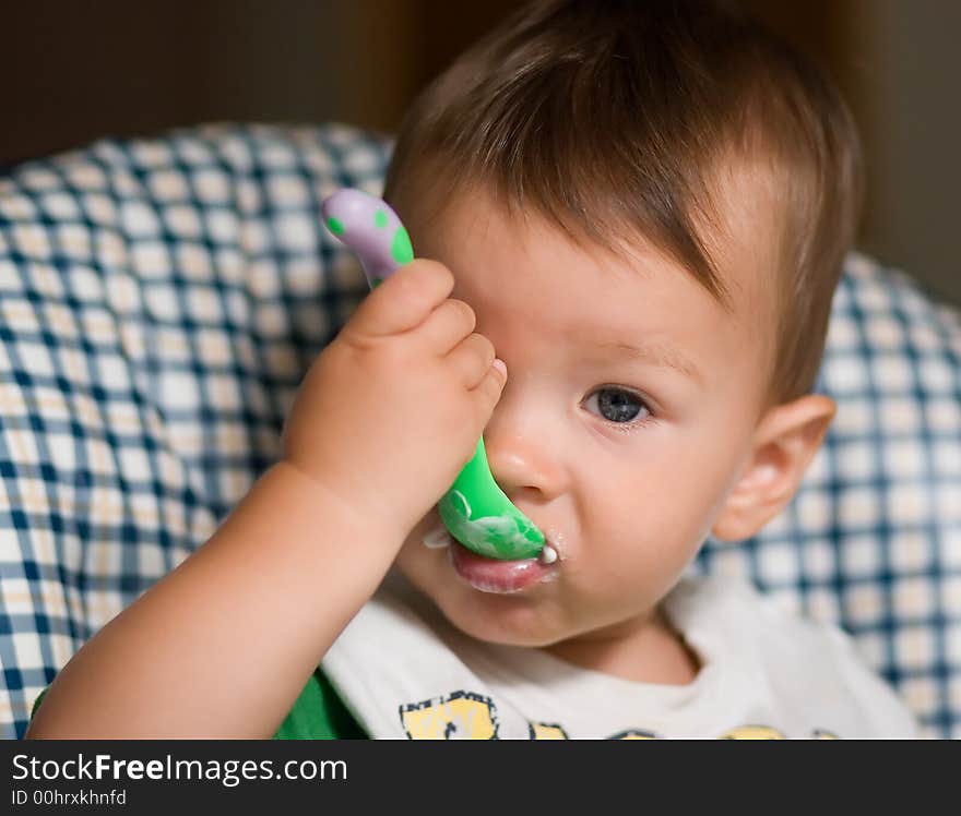 Little kid feeding by himself with a spoon. Little kid feeding by himself with a spoon