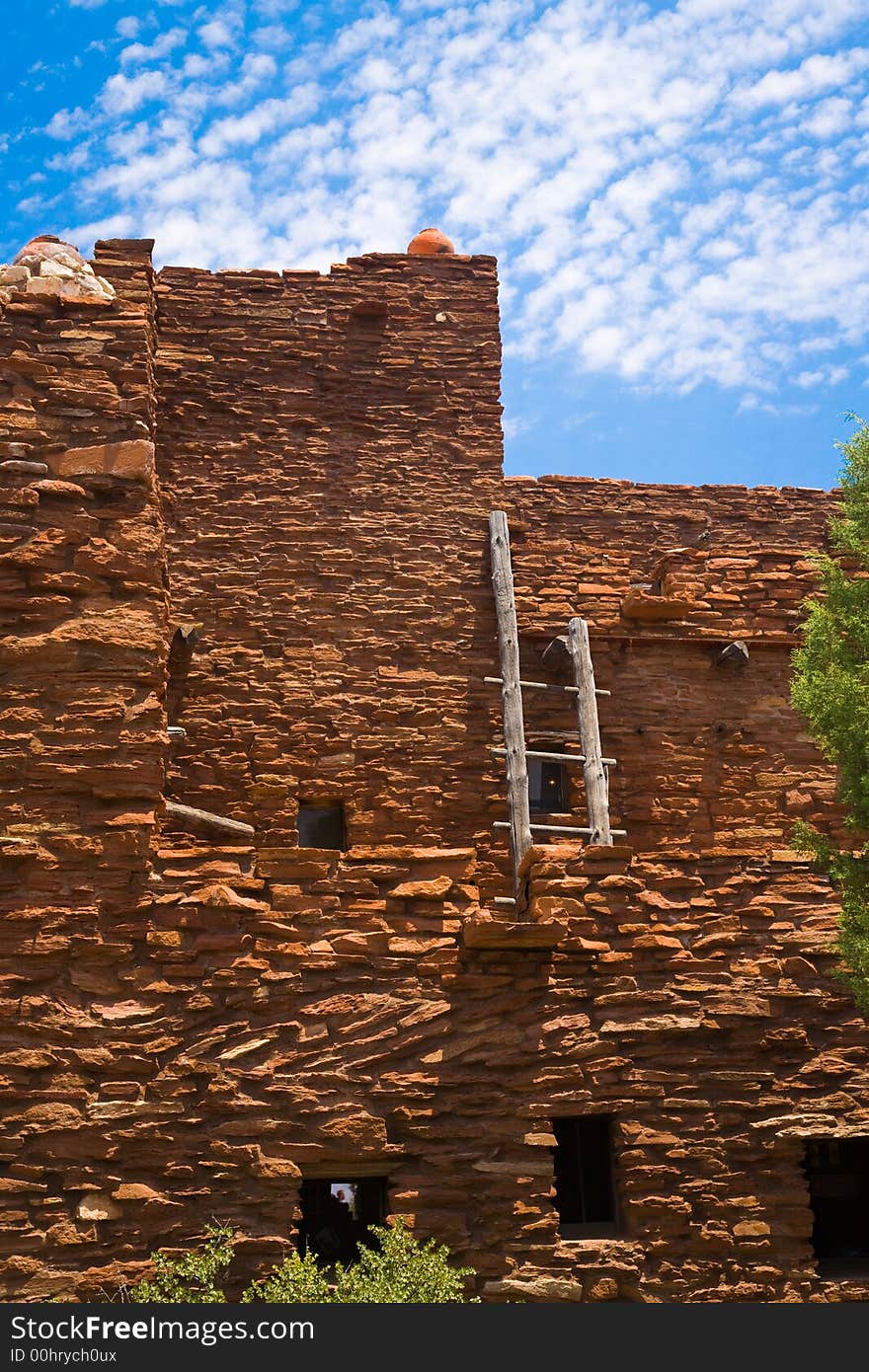 Adobe Red Rock house and latter with wispy white clounds and blue sky