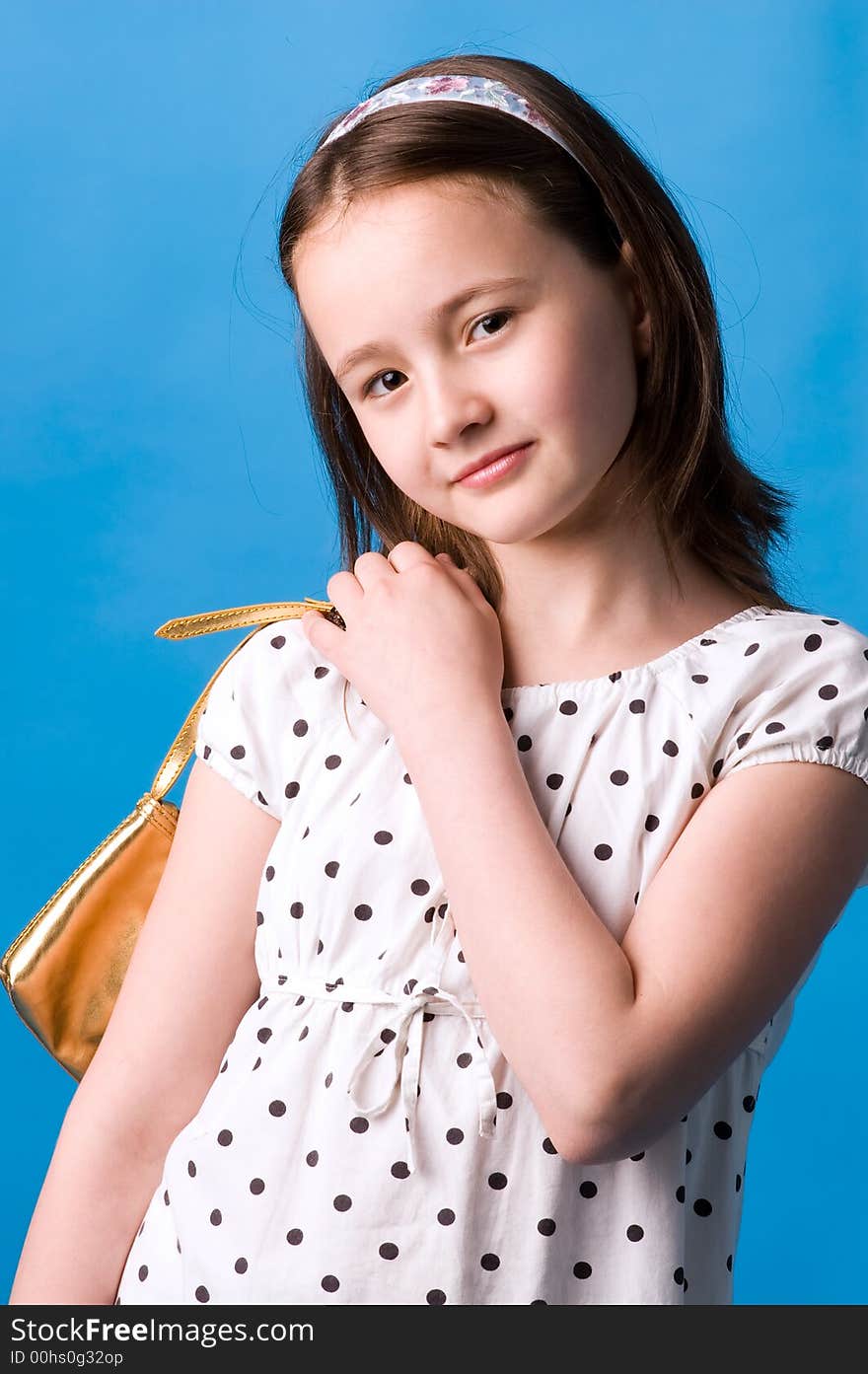 The girl of ten years poses with a gold handbag in a hand. The girl of ten years poses with a gold handbag in a hand