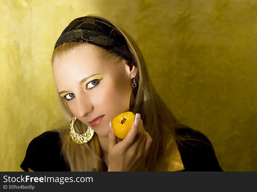 Attractive girl with apricot on yellow background