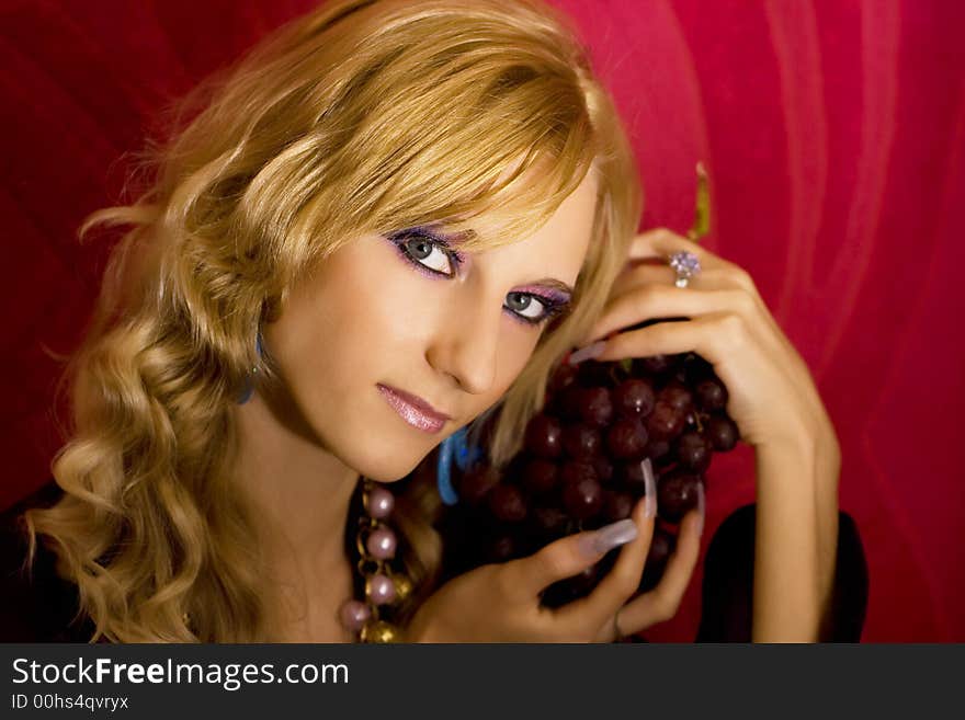 Young beautiful  blond girl with grapes