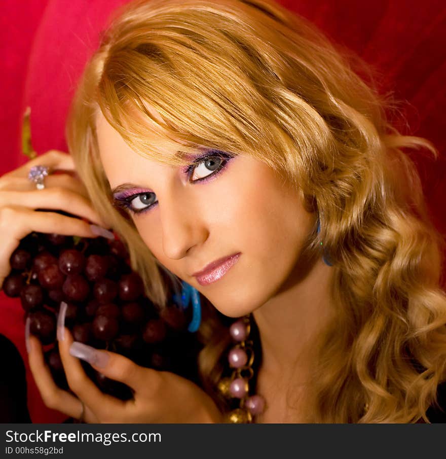 Young beautiful blond girl with grapes bunch